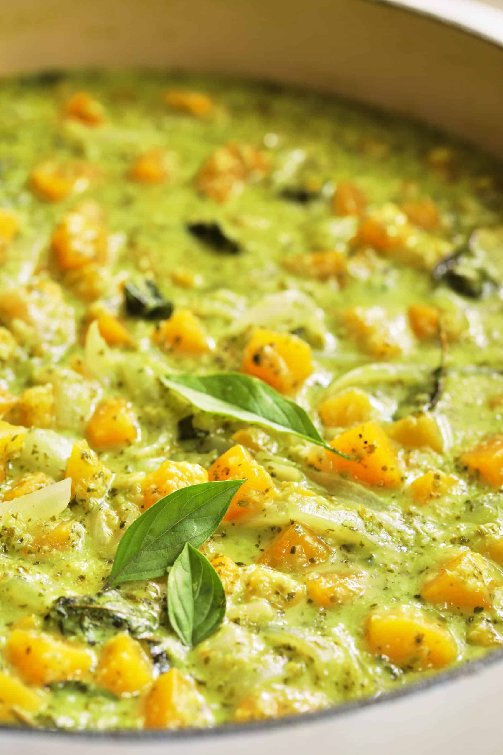 Close-up photo of Butternut Squash in Fresh Green Curry in white pan.