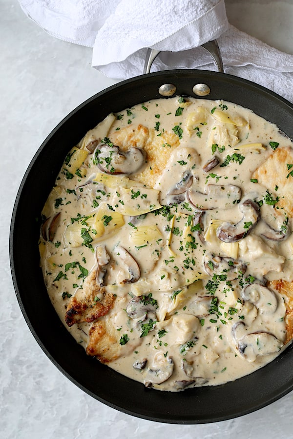 Turkey Scallopini in Sherry Cream Sauce with Mushrooms and Artichokes - Overhead close-up shot of finished dish in skillet