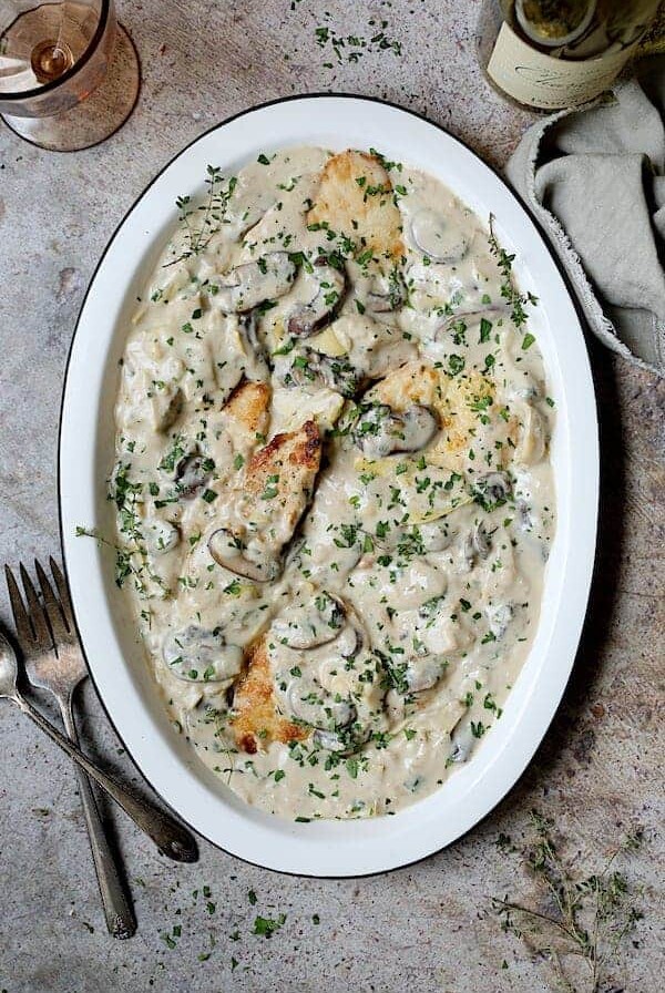 Turkey Scallopini in Sherry Cream Sauce with Mushrooms and Artichokes - Overhead shot of finished dish on white platter