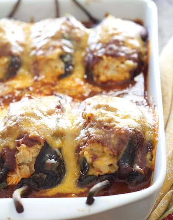 Photo of Chicken Brown Rice and Cheese-Stuffed Poblanos in white baking dish.