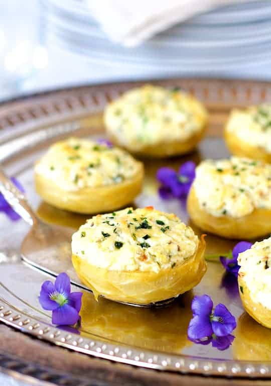 Photo of Goat Cheese Stuffed Artichoke Bottoms on silver platter garnished with violets.