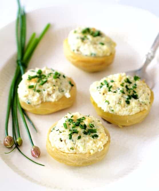 Photo of Goat Cheese Stuffed Artichoke Bottoms on white plate garnished with chopped fresh chives.