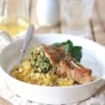 Sicilian Stuffed Pork Chops with White Wine Caper Sauce in white dish.