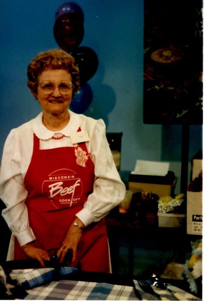 Photo of woman in red apron at beef cooking contest.