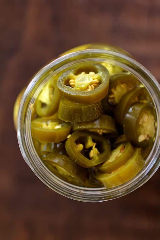 Photo of pickled jalapenos in glass jar.