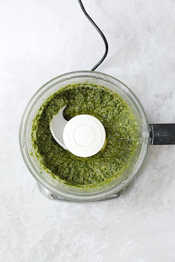 Photo of finished basil pesto in food processor.