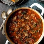 Sausage and Lentil Soup with Kale in white Dutch oven.