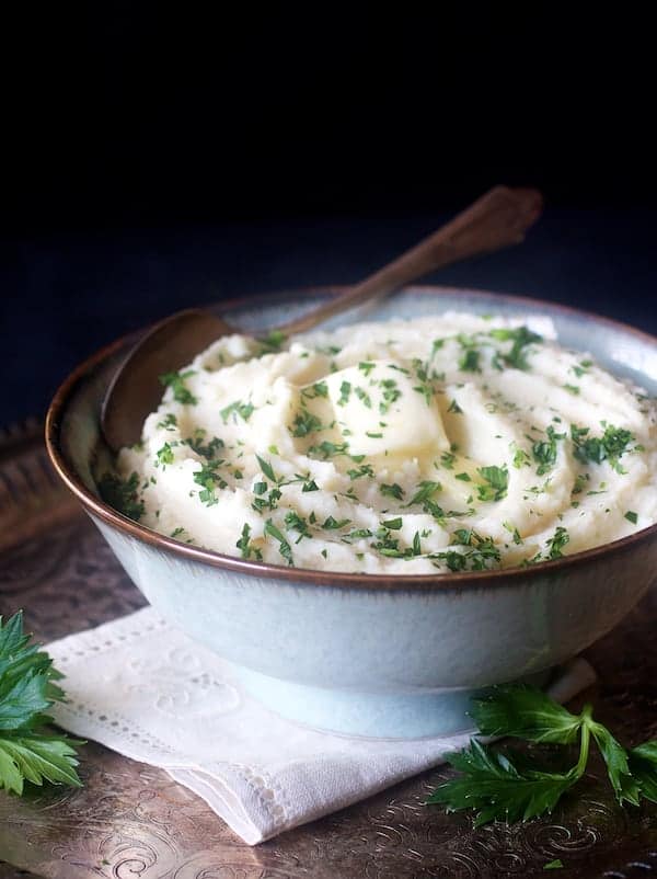 Photo of Celery Root Puree in serving bowl garnished with chopped parsley and a pat of butter.