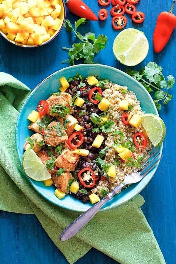 Cuban Chicken and Black Bean Quinoa Bowls garnished with lime wedges and cilantro.