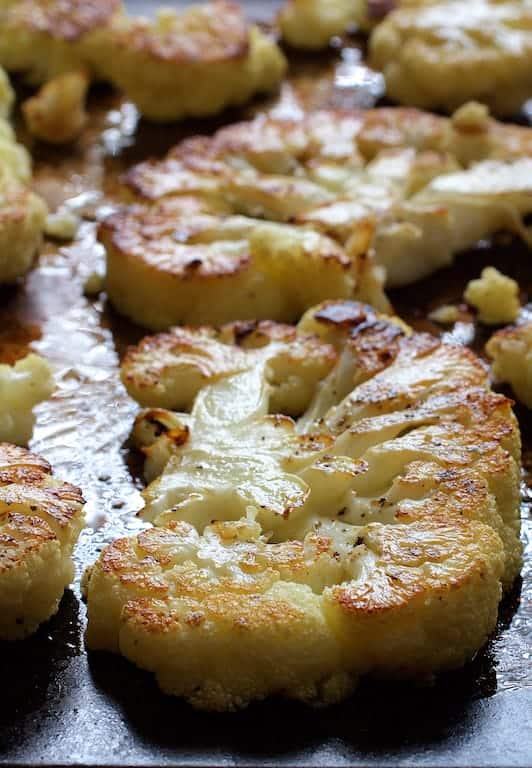 Photo of roasted cauliflower steaks on sheet pan.