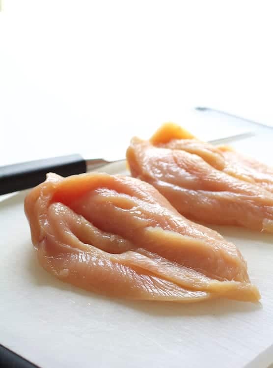 Photo of butterflied chicken breasts on cutting board.