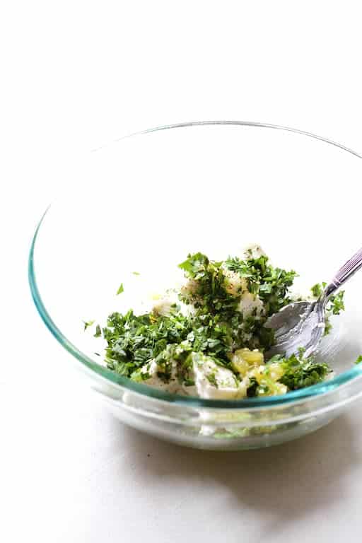 Photo of green chile and goat cheese mixture being mixed together in glass bowl.