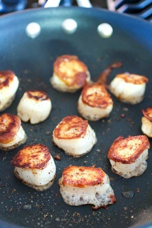 Photo of nicely browned sea scallops in nonstick skillet.
