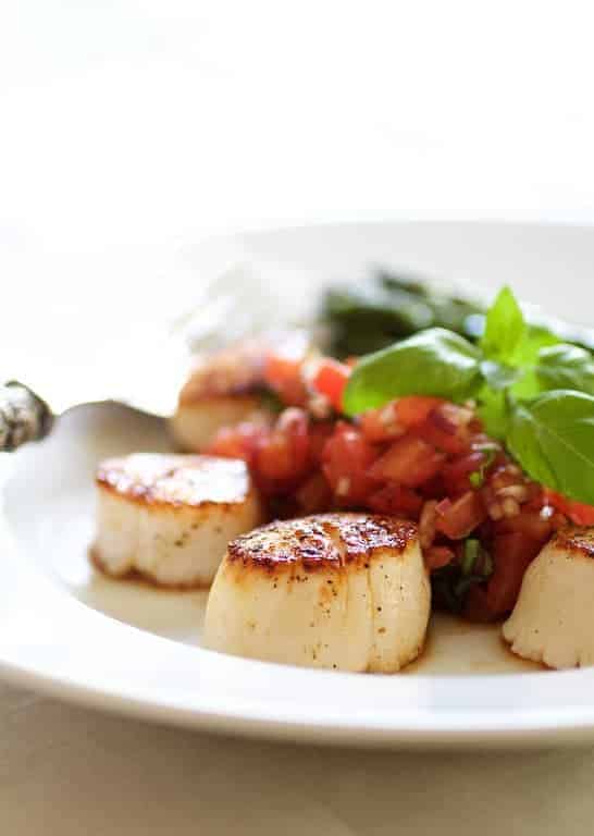 Seared Sea Scallops with Tomato, Red Onion and Balsamic Salsa on white plate.