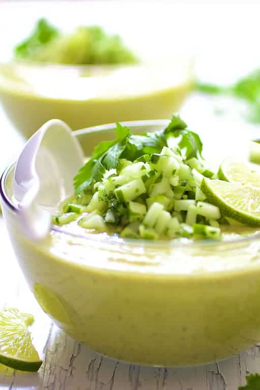 Close-up photo of Cold Thai Cucumber Avocado Soup with Cucumber Relish with white spoon.