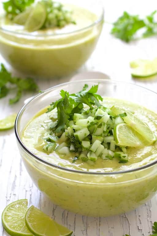 Photo of Cold Thai Cucumber Avocado Soup with Cucumber Relish on white distressed background.