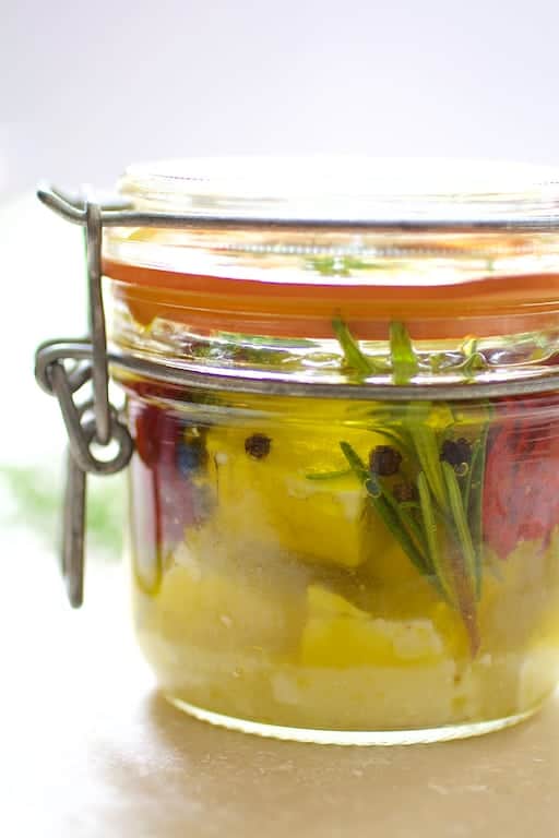 Close-up photo of a jar of marinated feta cheese.