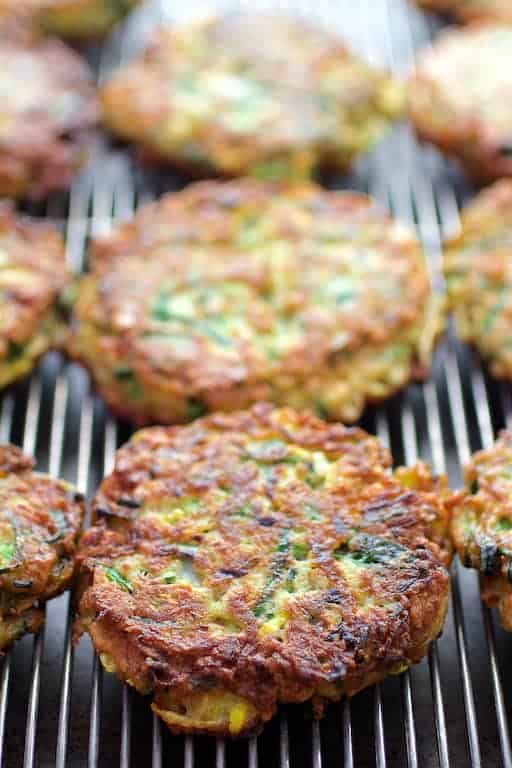 Photo of zucchini fritters on cooling rack after being fried.