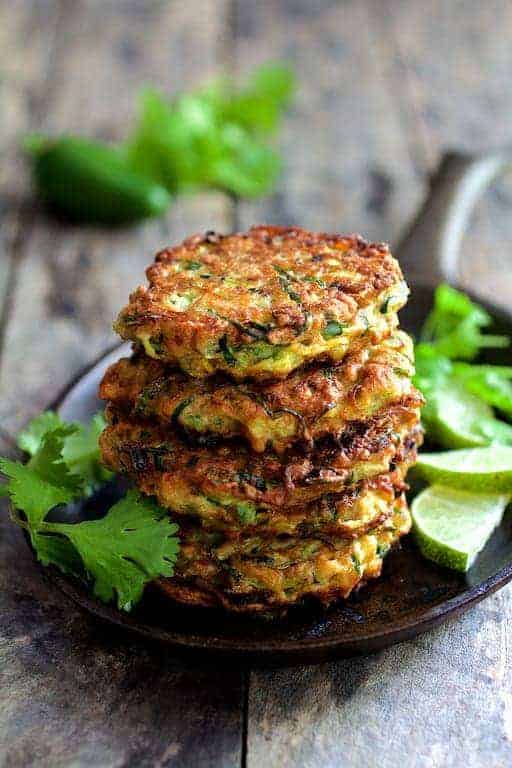 Stack of four Whole Grain Zucchini Jalapeno Fritters on small cast iron skillet.
