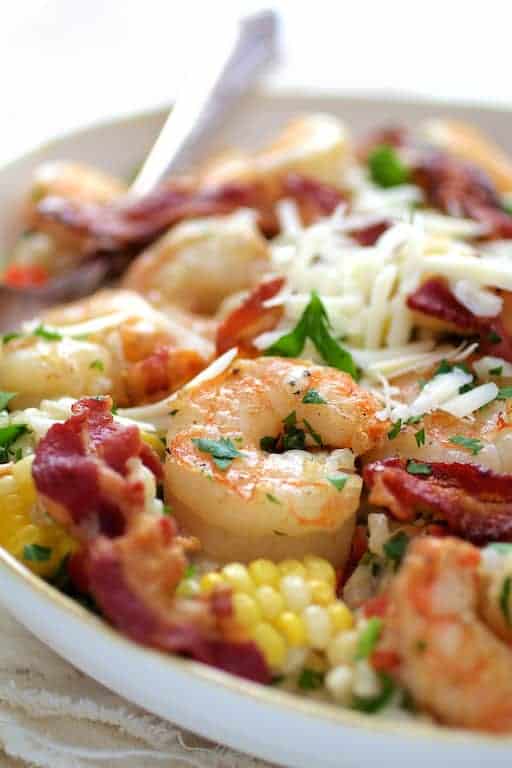Close-up photo of Shrimp and Corn Risotto with Bacon in white bowl.