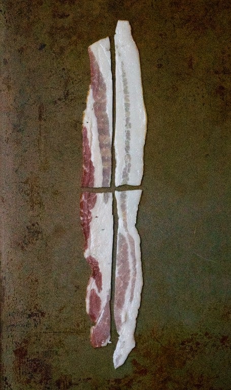 Photo of a strip of bacon cut into four "mini" slices for garnish.