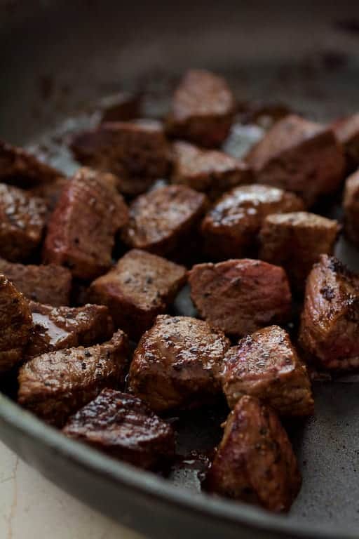 Photo of browned beef cubes in saute pan.