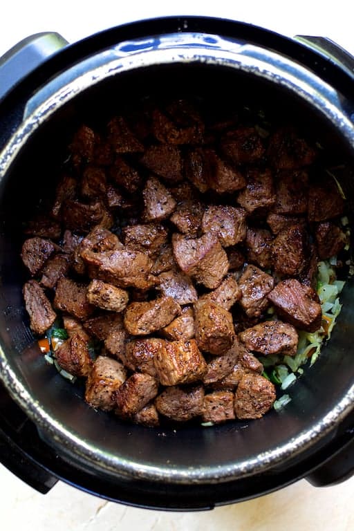 Photo of browned beef in electric pressure cooker.