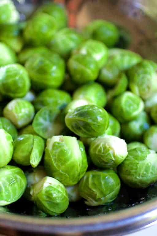 Photo of freshly trimmed Brussels sprouts in stainless steel colander.