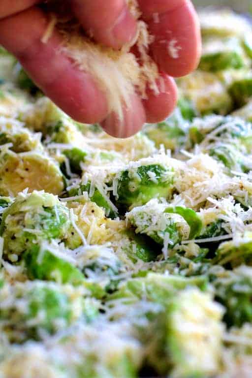 Photo of Brussels sprouts being sprinkled with Parmesan cheese.