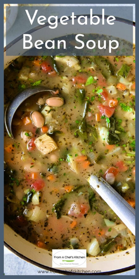Vegetable Bean Soup in white Dutch oven with soup ladle.