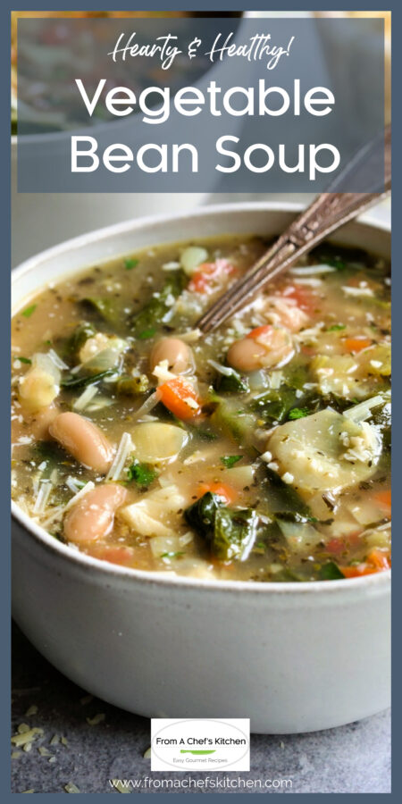 One serving of Vegetable Bean Soup in white bowl sprinkled with Parmesan cheese.