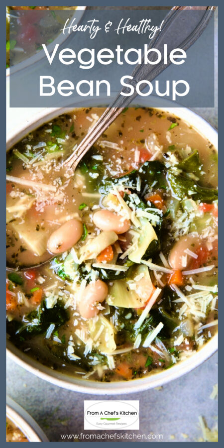 One serving of Vegetable Bean Soup in white bowl sprinkled with Parmesan cheese.