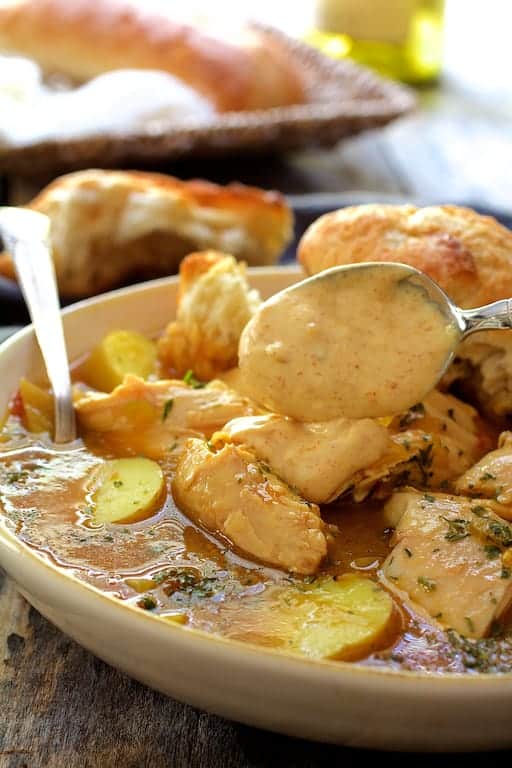 Photo of rouille being spooned onto the finished dish with a spoon.