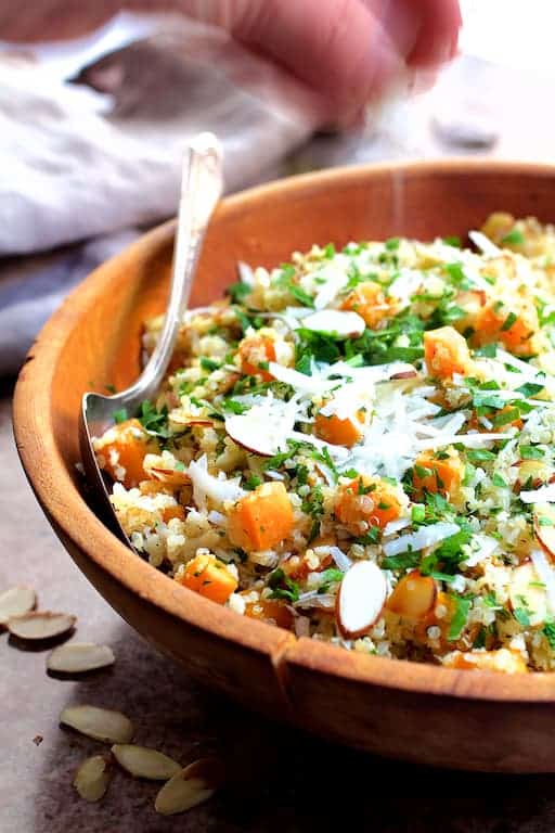 Photo of Lemony Quinoa with Roasted Butternut Squash Almonds and Parmesan Cheese being sprinkled with Parmesan cheese.