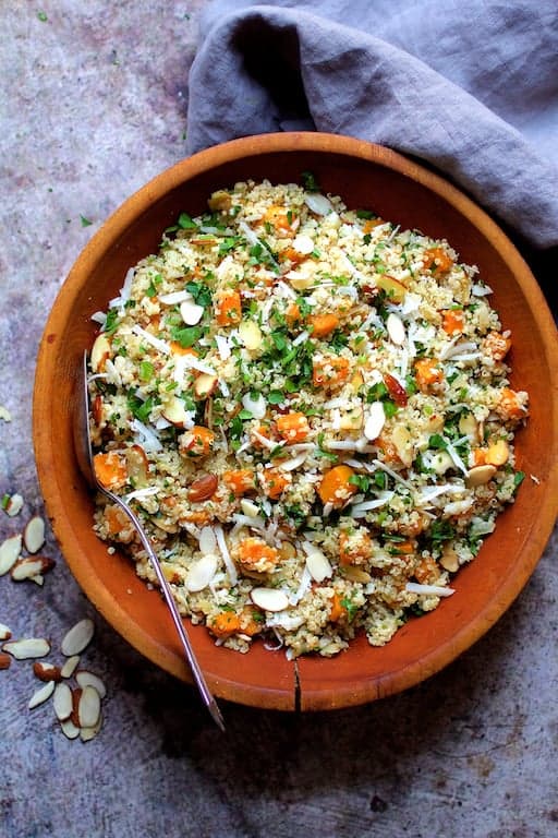 Photo of Lemony Quinoa with Butternut Squash, Almonds and Parmesan Cheese on gray surface in wood bowl.