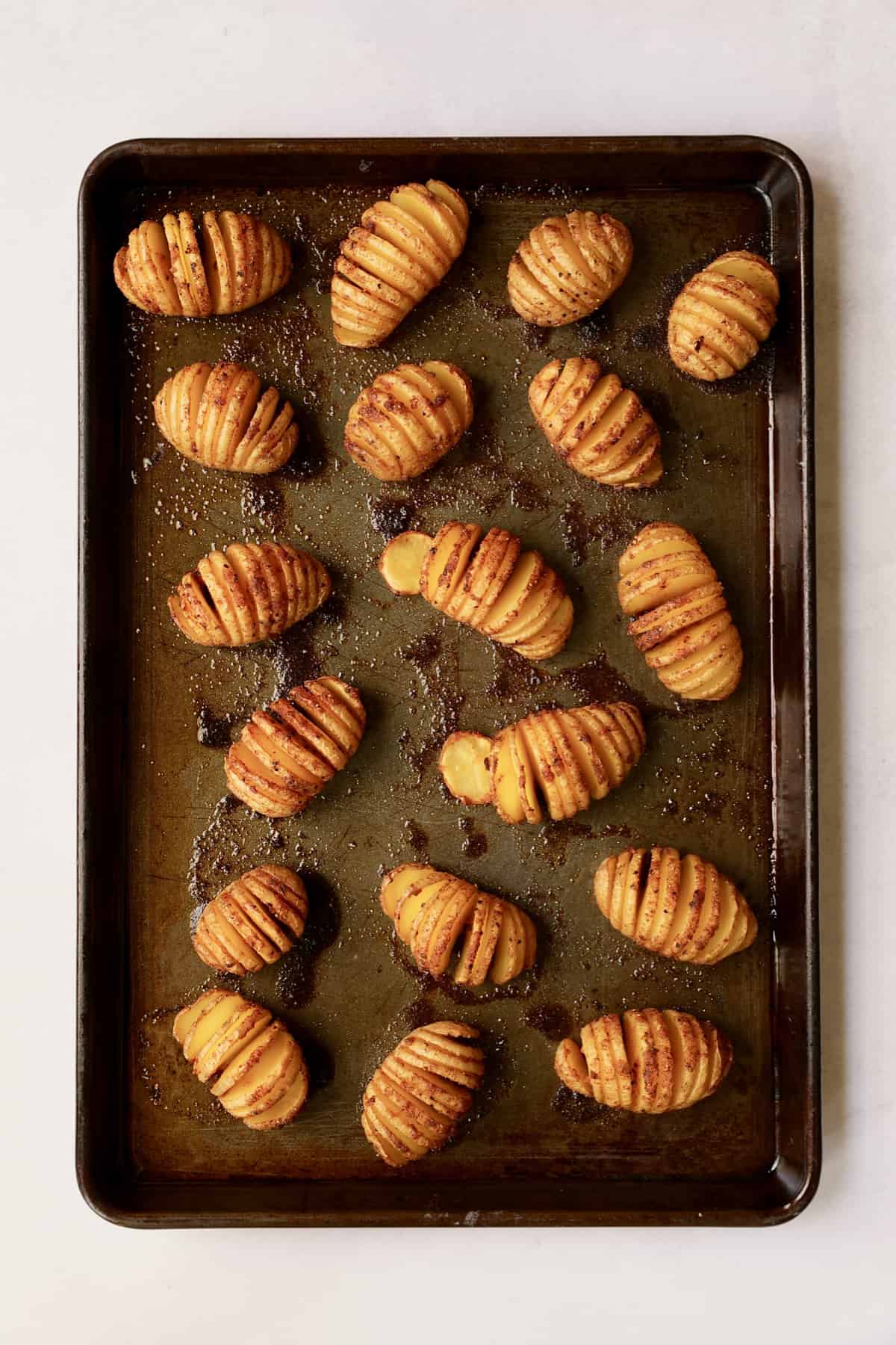 Photo of hasselbacked potatoes on baking sheet after being roasted.