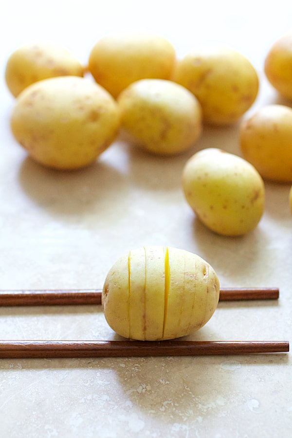 Photo of Yukon Gold potatoes on chopsticks after being hasselbacked.
