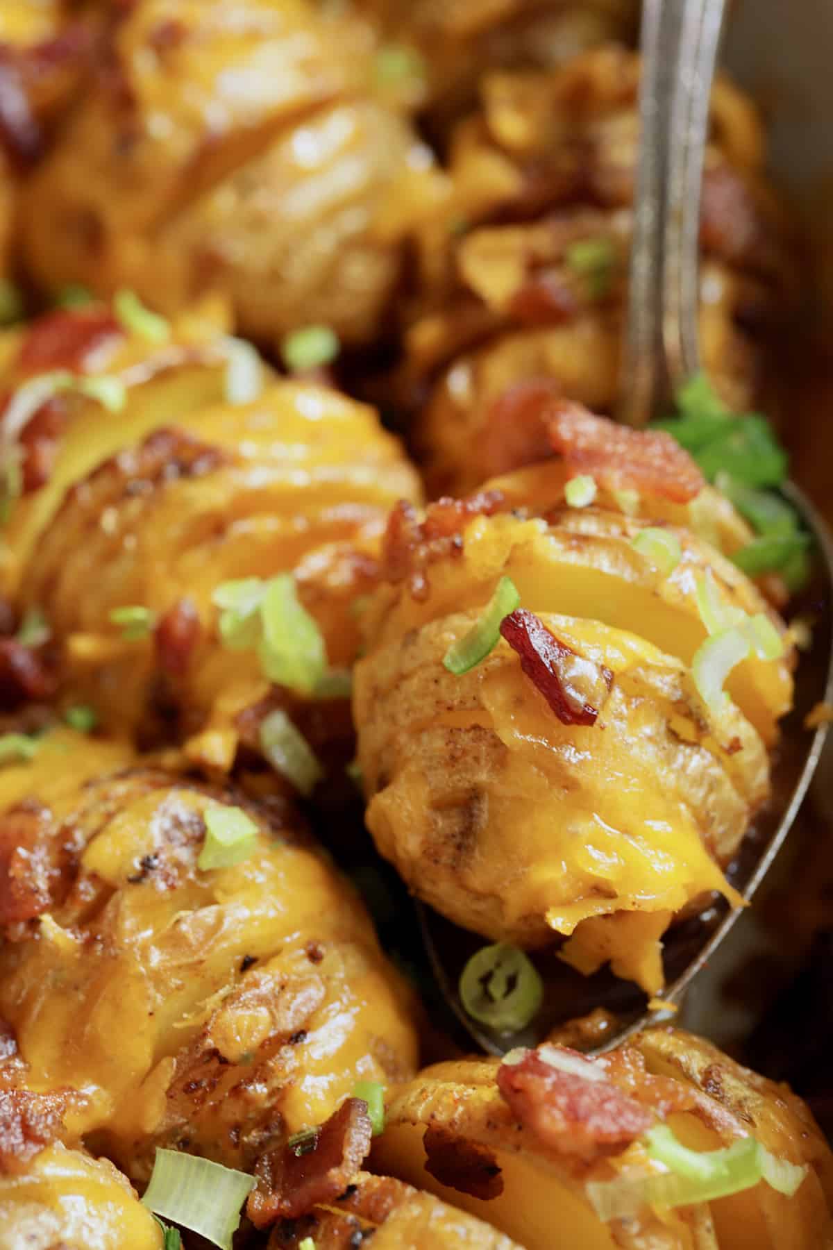 Close-up photo of one potato being served with serving spoon.