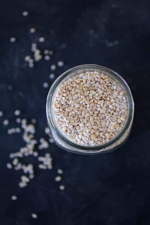 Photo of uncooked barley in a glass jar.
