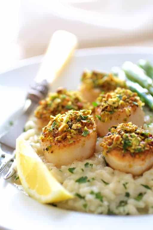 Close-up photo of Pistachio Encrusted Scallops with Champagne Risotto and Roasted Asparagus.
