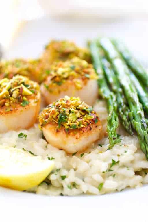 Close-up photo of Pistachio Encrusted Sea Scallops with Champagne Risotto and Roasted Asparagus.
