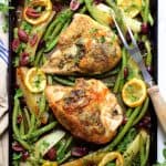 Sheet Pan Roast Chicken with Potatoes Green Beans Olives and Lemon on baking sheet with meat fork.