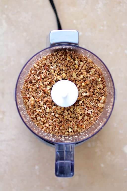 Photo of ground pecans in mini food processor.