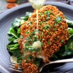 Baked Catfish Pecan Meuniere with butter being drizzled over a piece.