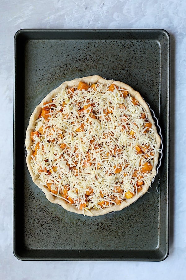 Photo of assembled Butternut Squash Leek and Gruyere Tart on baking sheet before custard is added.