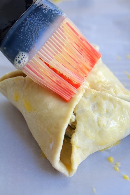 Photo of puff pastry parcel being brushed with egg.