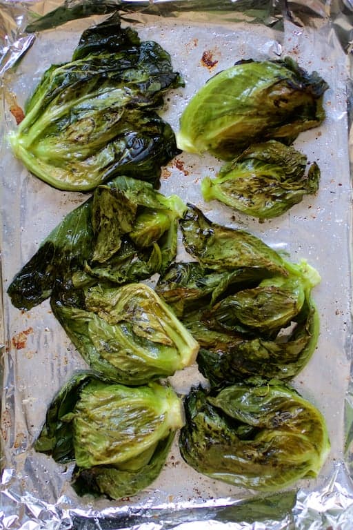 Photo of cabbage sprouts on baking sheet after being roasted.