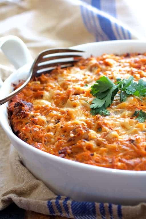 Photo of Spaghetti Pie with Three Cheeses in white baking dish on blue striped towel.