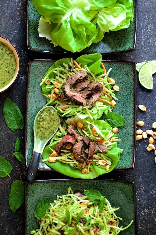 Photo of Thai Beef Lettuce Wraps with Mint Dressing and Vegetable Slaw on green square plates.
