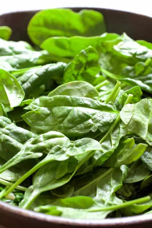 Photo of bowl full of fresh baby spinach.